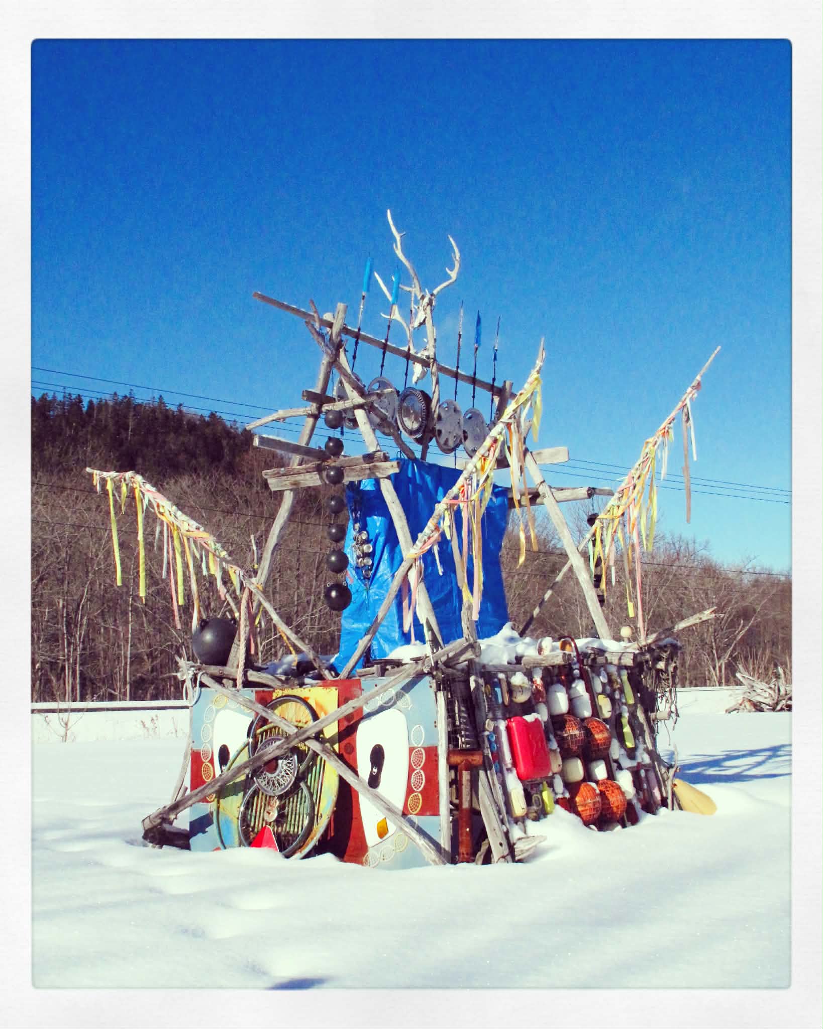 雪の中に展示された、角や廃材を組み合わせたカラフルな作品